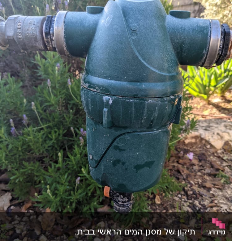 מסנן מים ירוק עם חיבורים מתכתיים בגינה